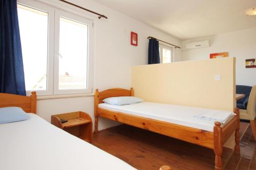 a room with two beds and two windows at Studio Orebic 10191f in Orebić