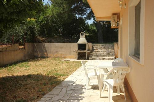 a patio with a table and chairs in a yard at Apartments and rooms with parking space Orebic, Peljesac - 10191 in Orebić