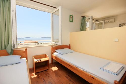 a room with two beds and a large window at Apartments and rooms with parking space Orebic, Peljesac - 10192 in Orebić
