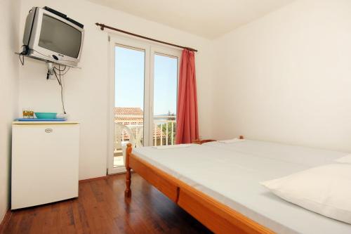 a bedroom with a bed with a tv on the wall at Twin Room Orebic 10192a in Orebić