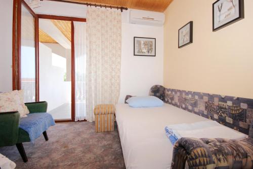 a bedroom with a bed and a chair and a window at Apartments with a parking space Orebic, Peljesac - 10193 in Orebić