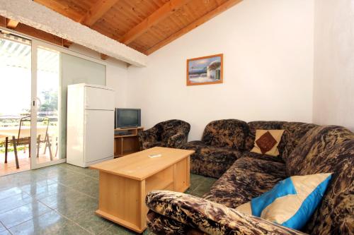 Apartments with a swimming pool Orebic, Peljesac - 10166 في أوربيك: غرفة معيشة مع أريكة وطاولة