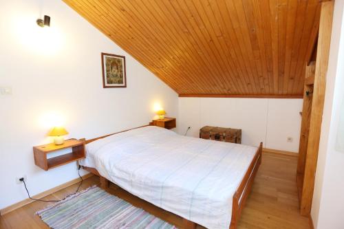 a bedroom with a bed and a wooden ceiling at Secluded fisherman's cottage Cove Bacva, Korcula - 9475 in Korčula