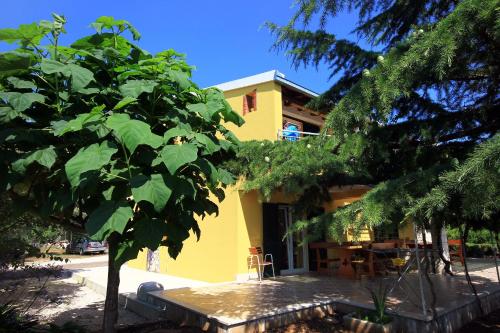 a yellow house with a tree in front of it at Apartments by the sea Loviste, Peljesac - 10197 in Lovište