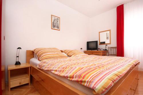 sypialnia z łóżkiem z kołdrą w paski w obiekcie Apartments by the sea Zrnovska Banja, Korcula - 10050 w Korčuli