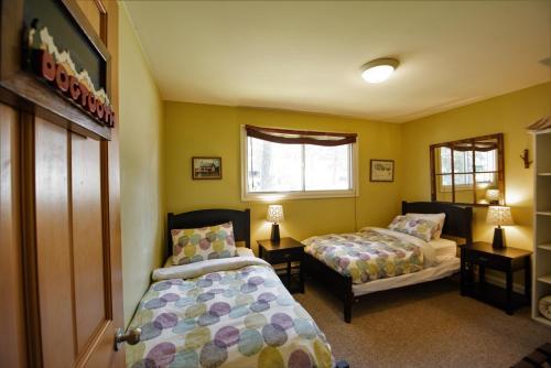 a bedroom with two beds and a window at Auberge Kicking Horse Guest House in Golden