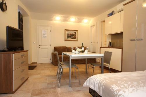 a room with a dining room table and a kitchen at Apartments by the sea Korcula - 10054 in Korčula