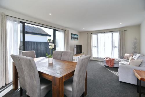 sala de estar con mesa de madera y sillas en Thomas Townhouse - Christchurch Holiday Homes en Christchurch