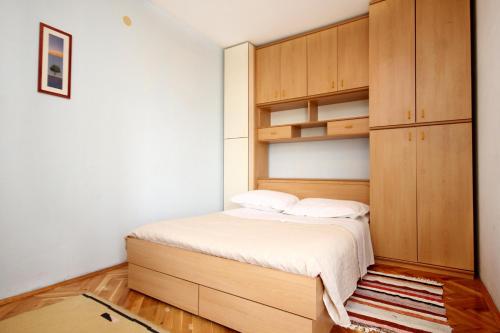 Holiday apartments Split - 10315 في سبليت: غرفة نوم صغيرة مع سرير وخزانة