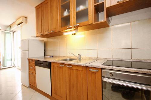a kitchen with wooden cabinets and a sink at Holiday apartments Split - 10315 in Split
