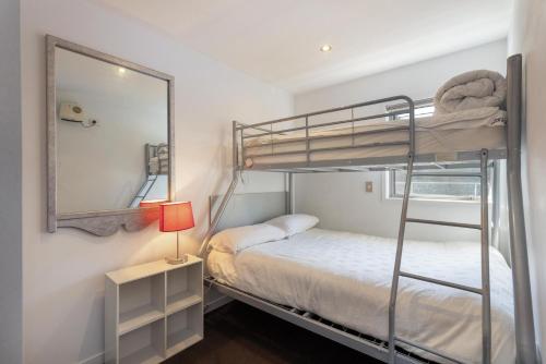 a bedroom with a bunk bed and a mirror at Ballarat Bungalow in Queenstown