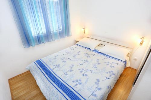 1 dormitorio con 1 cama con edredón azul y blanco en Apartments by the sea Marina, Trogir - 10327, en Marina