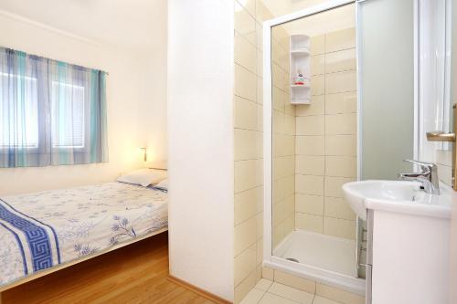 Baño pequeño con cama y lavabo en Apartments by the sea Marina, Trogir - 10327, en Marina