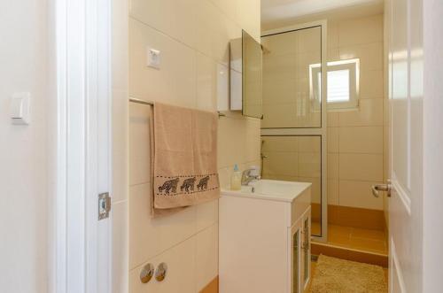 a white bathroom with a sink and a mirror at Apartments by the sea Prizba, Korcula - 10063 in Prizba