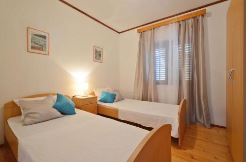 two beds in a small room with a window at Apartments by the sea Prizba, Korcula - 10063 in Prizba