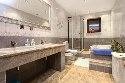 y baño con 2 lavabos, bañera y aseo. en Apartment Duce 10303a en Duće
