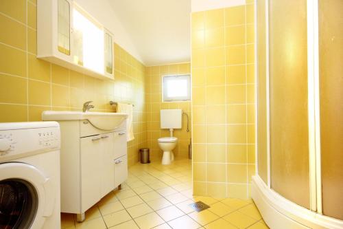 a bathroom with a washing machine and a toilet at Apartment Prizba 10061a in Prizba