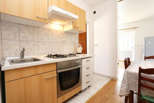 a kitchen with a sink and a stove at Apartment Orebic 10102c in Orebić