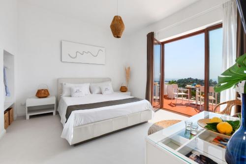 Habitación blanca con cama y balcón. en Villa Marianna, en Massa Lubrense