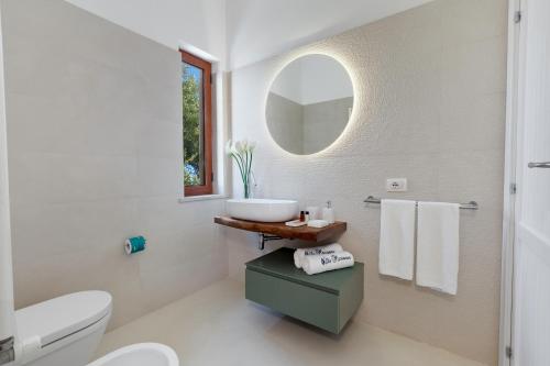 Baño blanco con lavabo y espejo en Villa Marianna, en Massa Lubrense