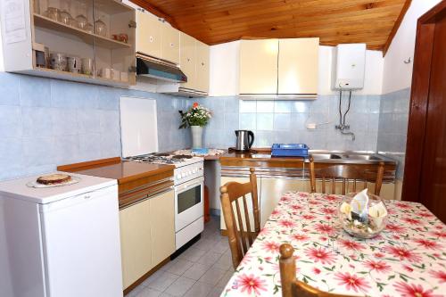 una pequeña cocina con mesa, mesa y sillas en Apartments by the sea Viganj, Peljesac - 10140, en Viganj