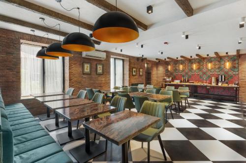 een restaurant met tafels en stoelen en een geruite vloer bij Hotel Old Wall in Tbilisi City