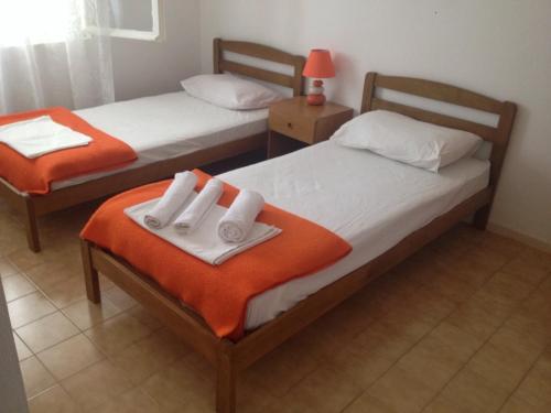 2 Betten mit orangefarbenen und weißen Handtüchern darauf in der Unterkunft Apartments by the sea Cove Pjestata, Peljesac - 10236 in Blaževo