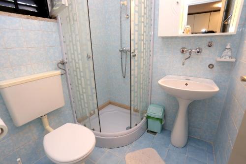La salle de bains est pourvue d'une douche, de toilettes et d'un lavabo. dans l'établissement Apartments by the sea Korcula - 10041, à Korčula