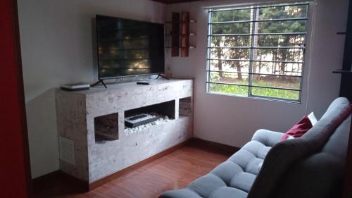 sala de estar con chimenea y TV en Hermoso acogedor y hogareño apartamento duplex tipo loft suba la campiña, en Bogotá