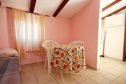 a table and chairs in a room with pink walls at Apartments by the sea Orebic, Peljesac - 10094 in Orebić