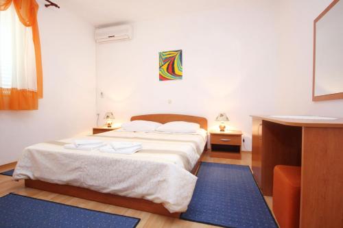 una camera da letto con un letto con lenzuola bianche e un tappeto blu di Apartments and rooms with parking space Orebic, Peljesac - 10085 a Orebić (Sabbioncello)