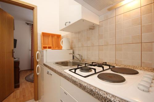 una cucina con fornelli e lavello di Apartments and rooms with parking space Orebic, Peljesac - 10085 a Orebić (Sabbioncello)