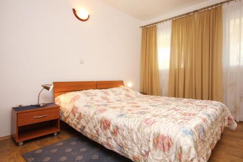 a bedroom with a bed and a dresser with a lamp at Apartments with a parking space Orebic, Peljesac - 10092 in Orebić
