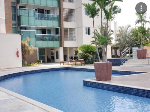 a swimming pool in front of a building at Lindo flat Easy Life in Goiânia