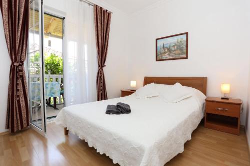 1 Schlafzimmer mit einem weißen Bett und einem Balkon in der Unterkunft Apartments with a parking space Orebic, Peljesac - 10103 in Orebić