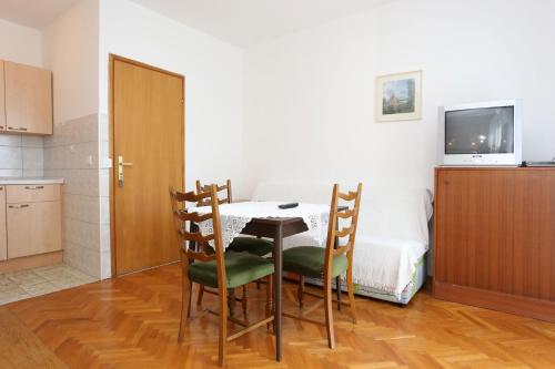 a room with a table and chairs and a bed at Apartments with a parking space Trpanj, Peljesac - 10111 in Trpanj