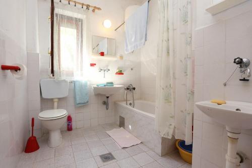 a bathroom with a toilet and a sink and a tub at Apartments by the sea Sreser, Peljesac - 10227 in Janjina