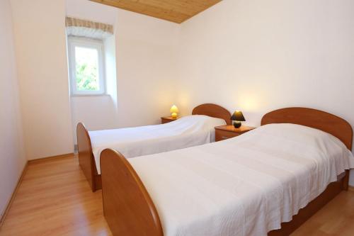 two beds in a room with white walls and a window at Family friendly apartments with a swimming pool Kuciste - Perna, Peljesac - 10143 in Kučište