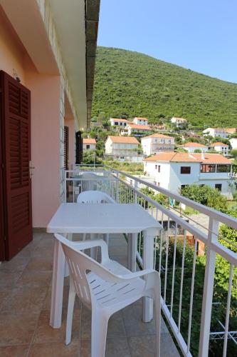 a white table and chairs on a balcony with a view at Apartments with parking space Trpanj, Peljesac - 10148 in Trpanj