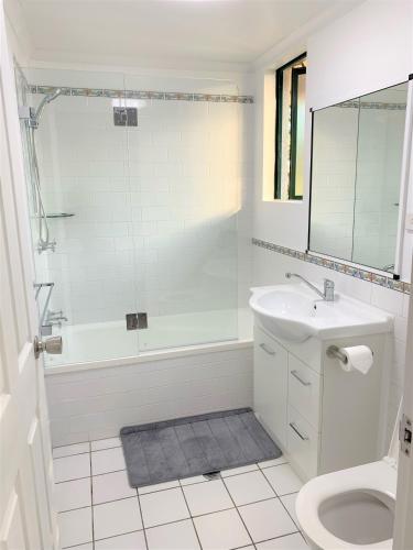 a bathroom with a tub and a sink and a toilet at Cairns Affordable Getaway in Cairns North