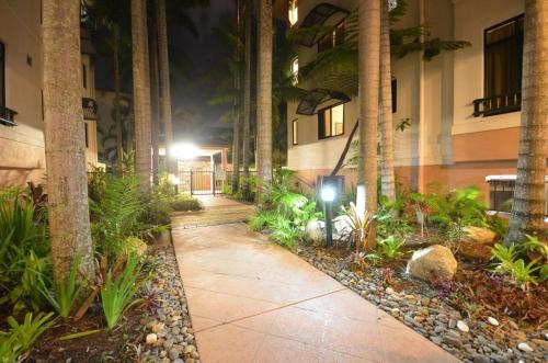 een loopbrug voor een gebouw met palmbomen bij Cairns Affordable Getaway in Cairns North