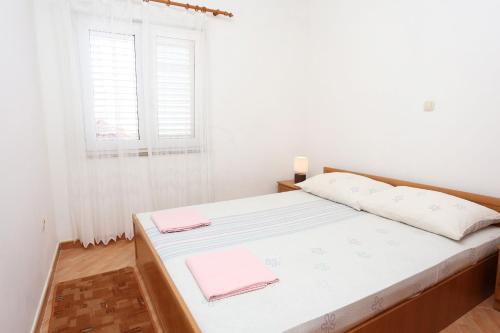 a bedroom with a bed with white walls and a window at Apartments by the sea Brijesta, Peljesac - 10223 in Brijesta