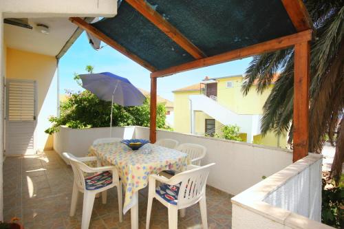 a table and chairs on a balcony with an umbrella at Apartments with a parking space Orebic, Peljesac - 10177 in Orebić