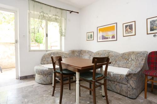 a living room with a table and a couch at Holiday apartments Duba Peljeska, Peljesac - 10230 in Orebić