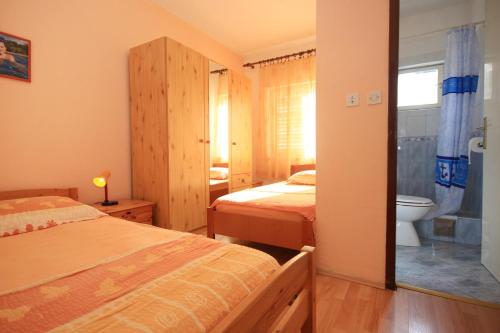 a bedroom with two beds and a bathroom with a toilet at Apartments with a parking space Orebic, Peljesac - 10171 in Orebić