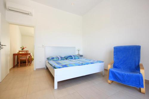 a bedroom with a bed and a blue chair at Apartments with parking space Orebic, Peljesac - 10173 in Orebić