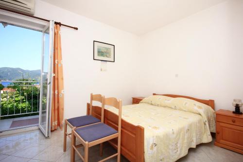 a bedroom with a bed and a chair and a window at Apartments with parking space Viganj, Peljesac - 10188 in Viganj
