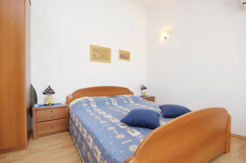 Un dormitorio con una cama con cabecero de madera. en Apartments with parking space Orebic, Peljesac - 10194, en Orebić