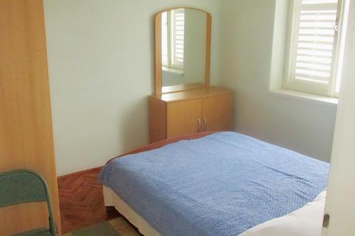 een slaapkamer met een blauw bed en een spiegel bij Seaside holiday house Susica, Ugljan - 9664 in Ugljan