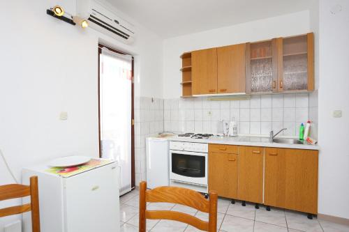 波茲塔納的住宿－Apartments by the sea Podstrana, Split - 9503，厨房配有水槽和炉灶